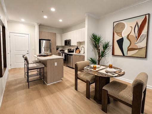 A modern kitchen with a dining table set for two.