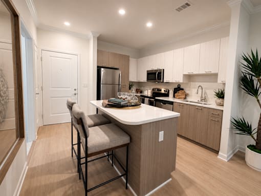 A kitchen with a table and chairs in the middle of the room.