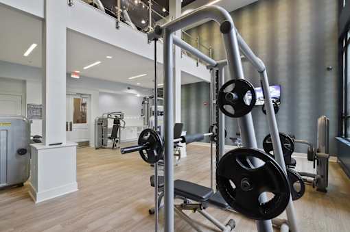A gym with a variety of equipment including a squat rack.