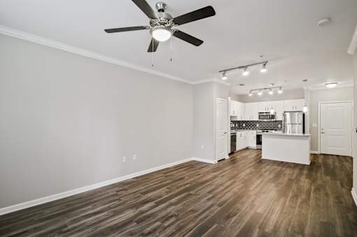 A room with a ceiling fan and wooden flooring.
