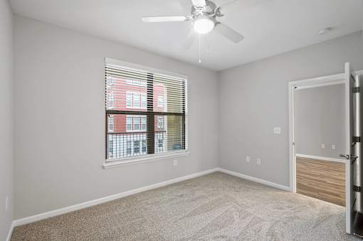A room with a window and a ceiling fan.