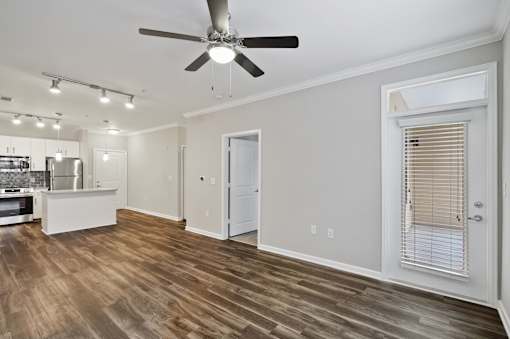 A room with a ceiling fan and wooden flooring.