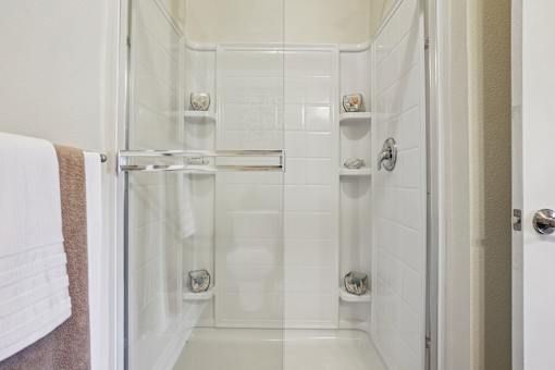 A white bathroom with a walk in shower.