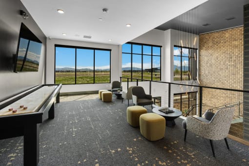 a living room with a view of a field and a table and chairs