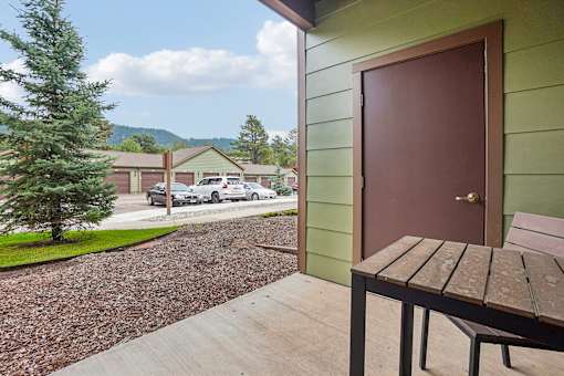 A brown door is on a green building.