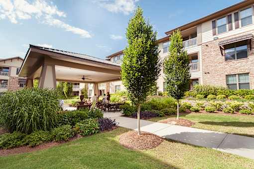 A large building with a covered walkway and a tree in front.