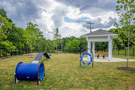 A playground with a blue barrel and a gazebo.