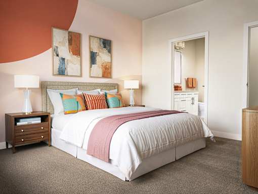 A bedroom with a large bed and two lamps.