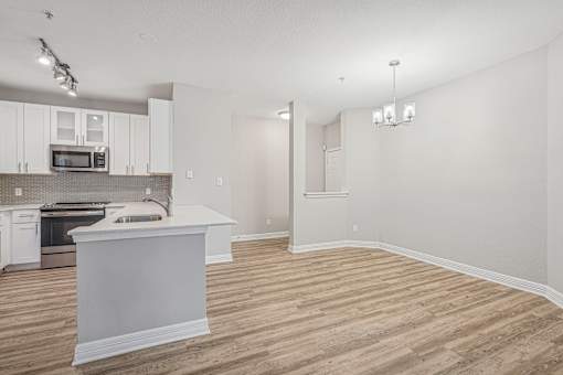A kitchen with white cabinets and a white island.