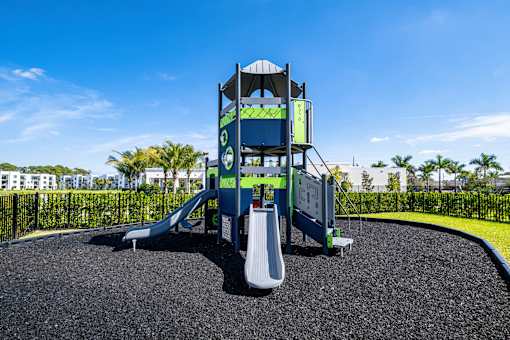 A playground with a blue slide and a white slide.