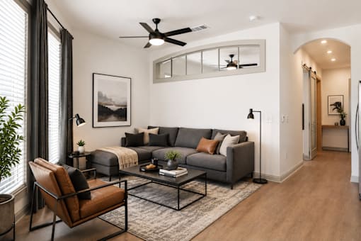 A living room with a grey couch, a black chair, and a coffee table.