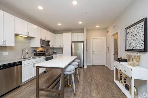 A kitchen with a table and chairs in the middle of the room.