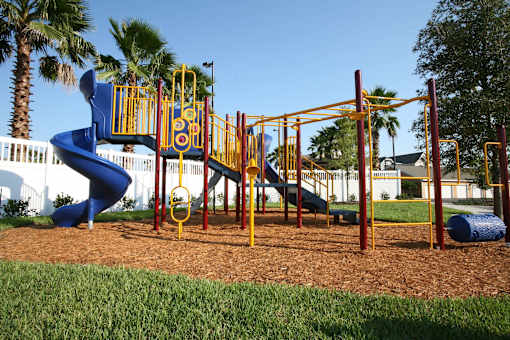 A playground with a blue slide and yellow and red play equipment.