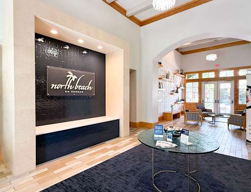 A reception area with a glass table and chairs.