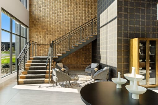 a lobby with a staircase and a table and chairs