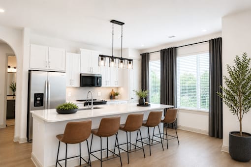 A modern kitchen with a white island and brown barstools.