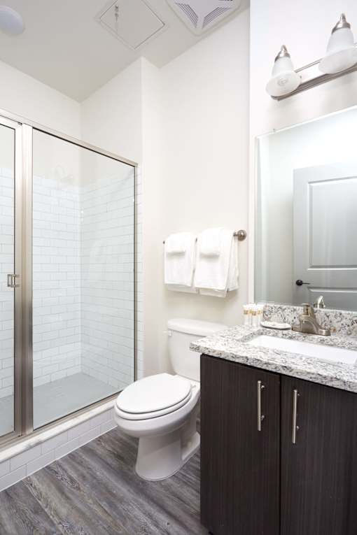 A white toilet sits in a bathroom next to a sink.