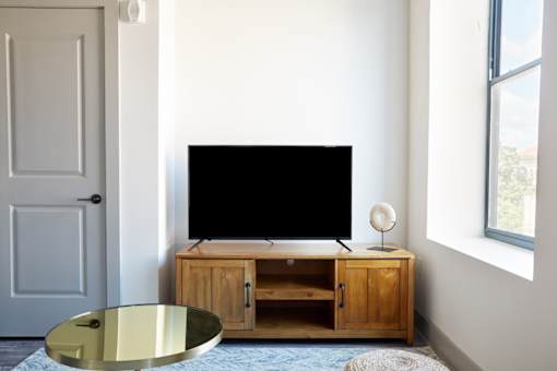 A black screen on a wooden cabinet sits next to a door.