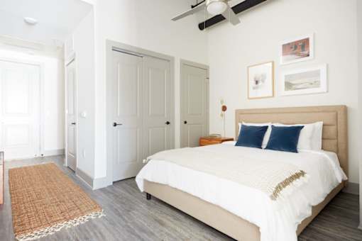 A bedroom with a large bed and a ceiling fan.