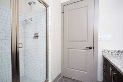 A white door is in a bathroom with a marble counter.