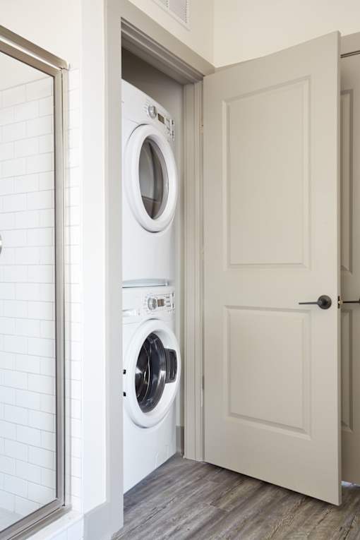 A white door is open to a laundry room with a washer and dryer.