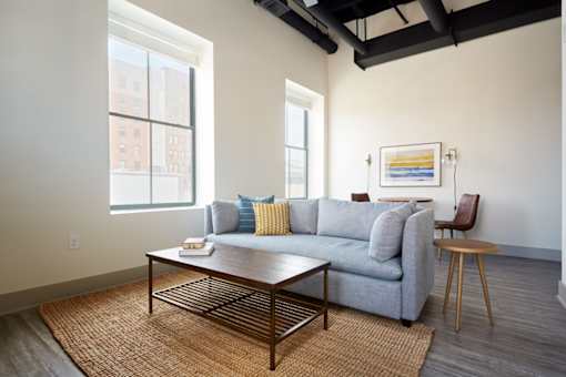 A living room with a grey couch and a coffee table.