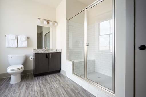 A white toilet sits next to a wooden cabinet in a bathroom.