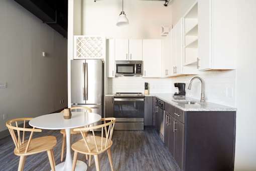 A kitchen with a table and chairs.