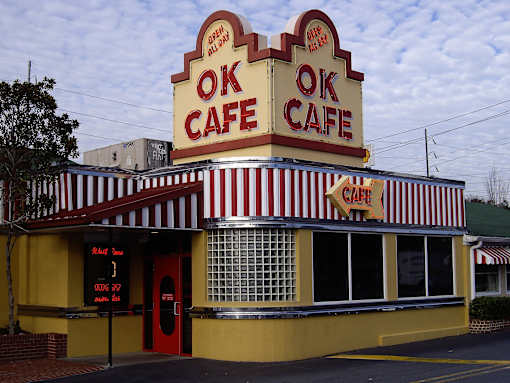A yellow and red striped building with the words "OK CAFE" on top.