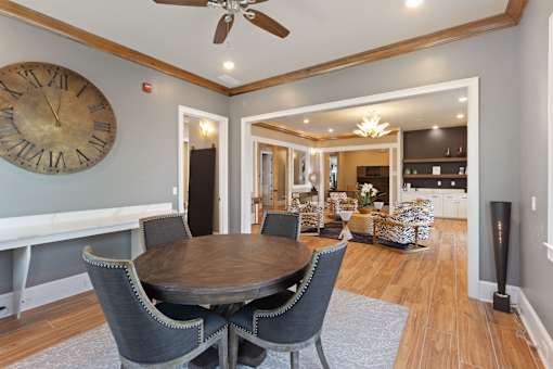 a dining room with a large clock on the wall and a dining table