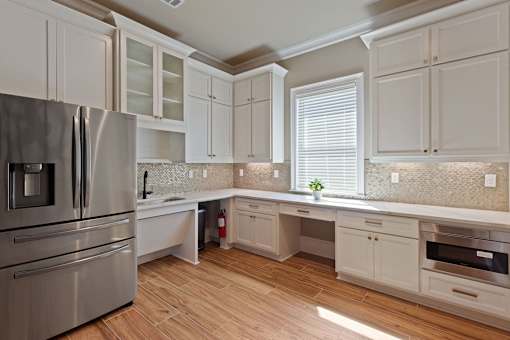 a kitchen with white cabinets and stainless steel appliances