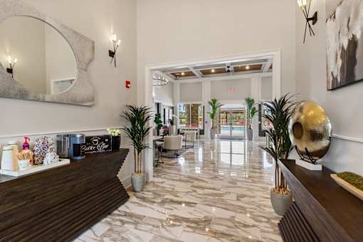 the lobby of a hotel with a reception desk and potted plants