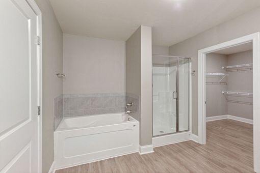 a bathroom with a tub and a shower and a closet