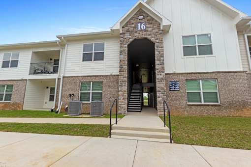 an exterior view of an apartment building with stairs and a sidewalk