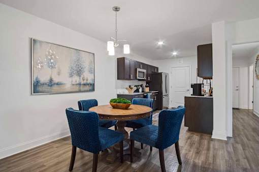 A dining room with a table and chairs.