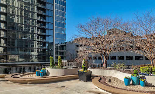 A courtyard with a circular design and a tall building in the background.