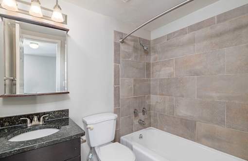 A bathroom with a toilet, sink, and tub.