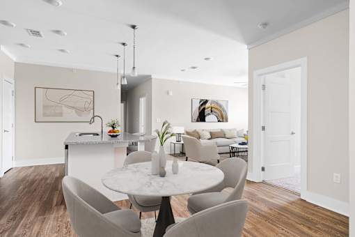 A modern dining room with a marble table and grey chairs.