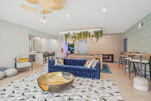 A living room with a blue sofa and a gold bowl on the floor.
