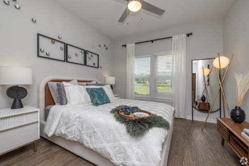 A bedroom with a bed, nightstand, and a mirror.