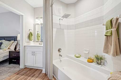 A bathroom with a white tub and a white shower curtain.