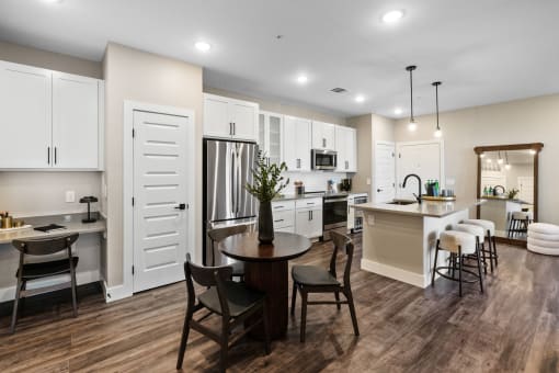 a kitchen and dining room with white cabinets and a table