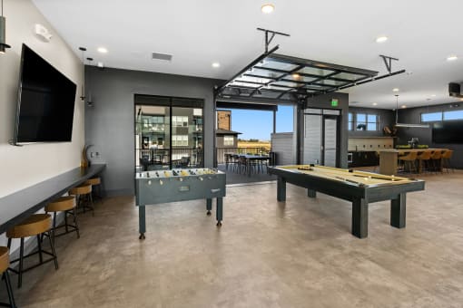 a games room with two pool tables and a tv