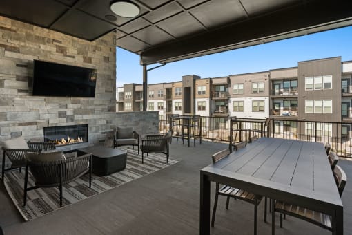 a patio with a table and chairs and a fireplace