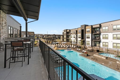 a resort style pool with tables and chairs on a balcony