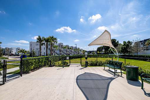 A park with a bench and a shade structure.