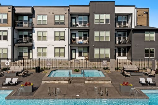 a swimming pool is in front of an apartment building