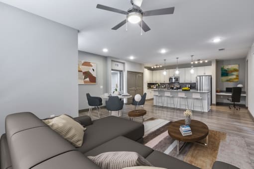 a living room and kitchen with a couch and a ceiling fan
