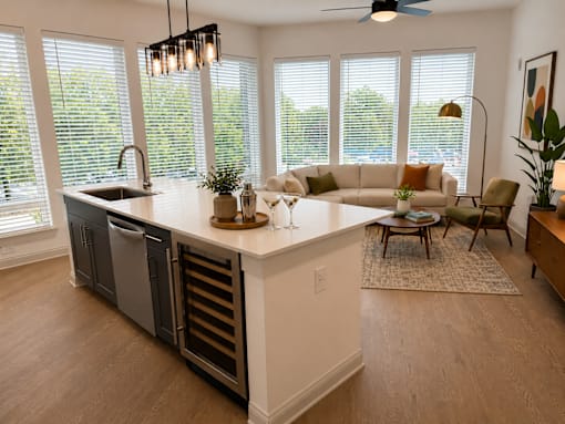 A kitchen with a large island and a dining table with chairs.