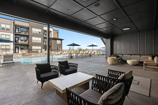 a large patio with chairs and tables and a pool